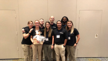 Group of physical therapy students huddle together and celebrate their second place win at quiz bowl