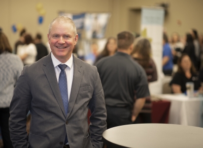 Man stands in front of crowded Job Fair venue