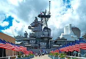A naval military base sits on the water surrounded by American flags