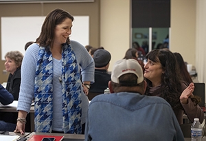 A woman speaks with two attendees at her workshop.