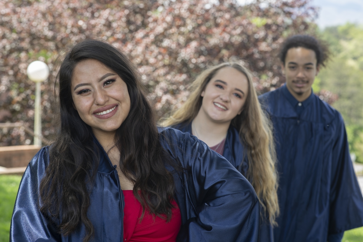 Three graduates smile for the camera