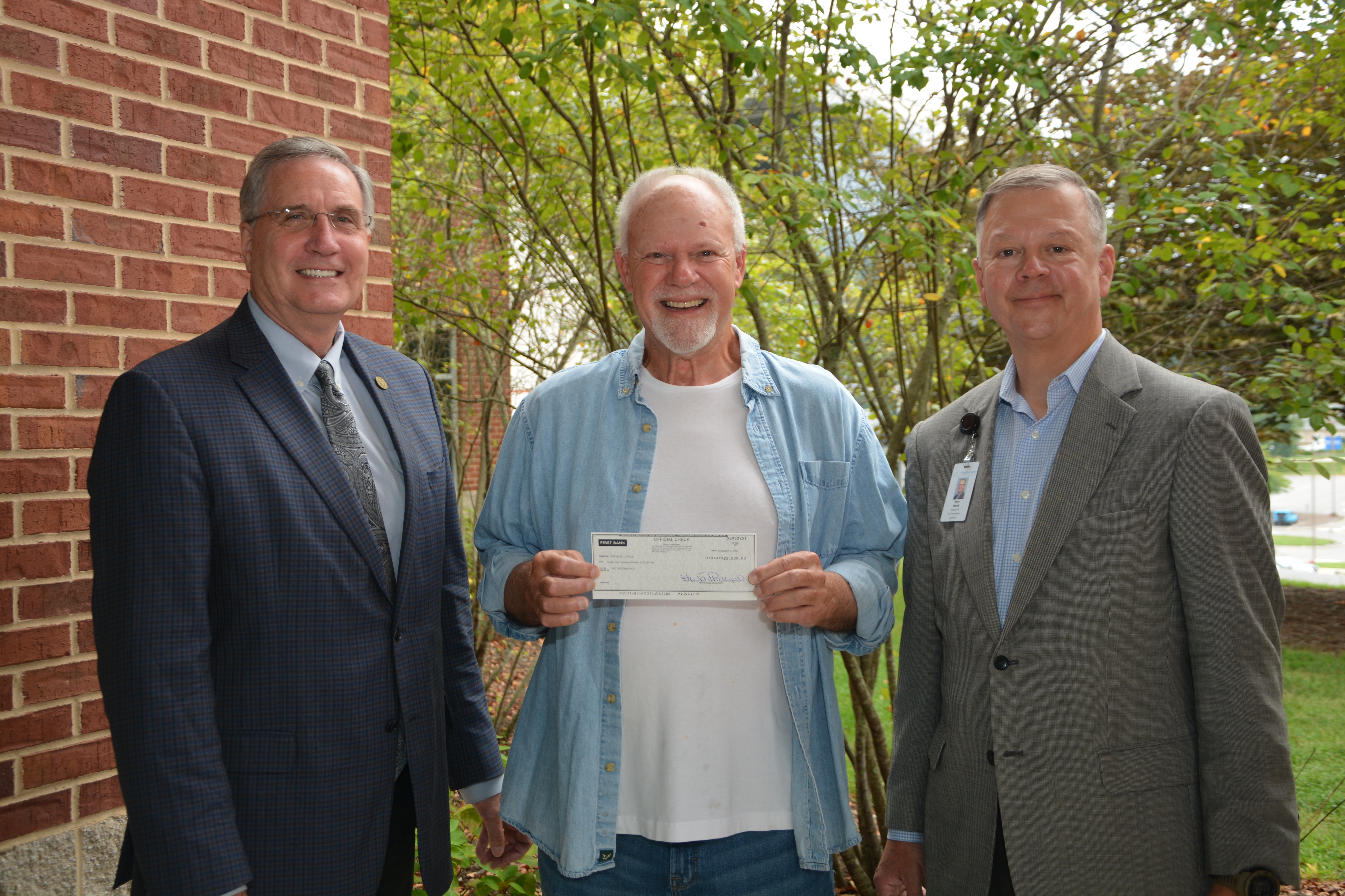 Mike Wade (center) stands between Dr. Don Tomas, SCC's President, and Brett Woods, Director of the SCC Foundation