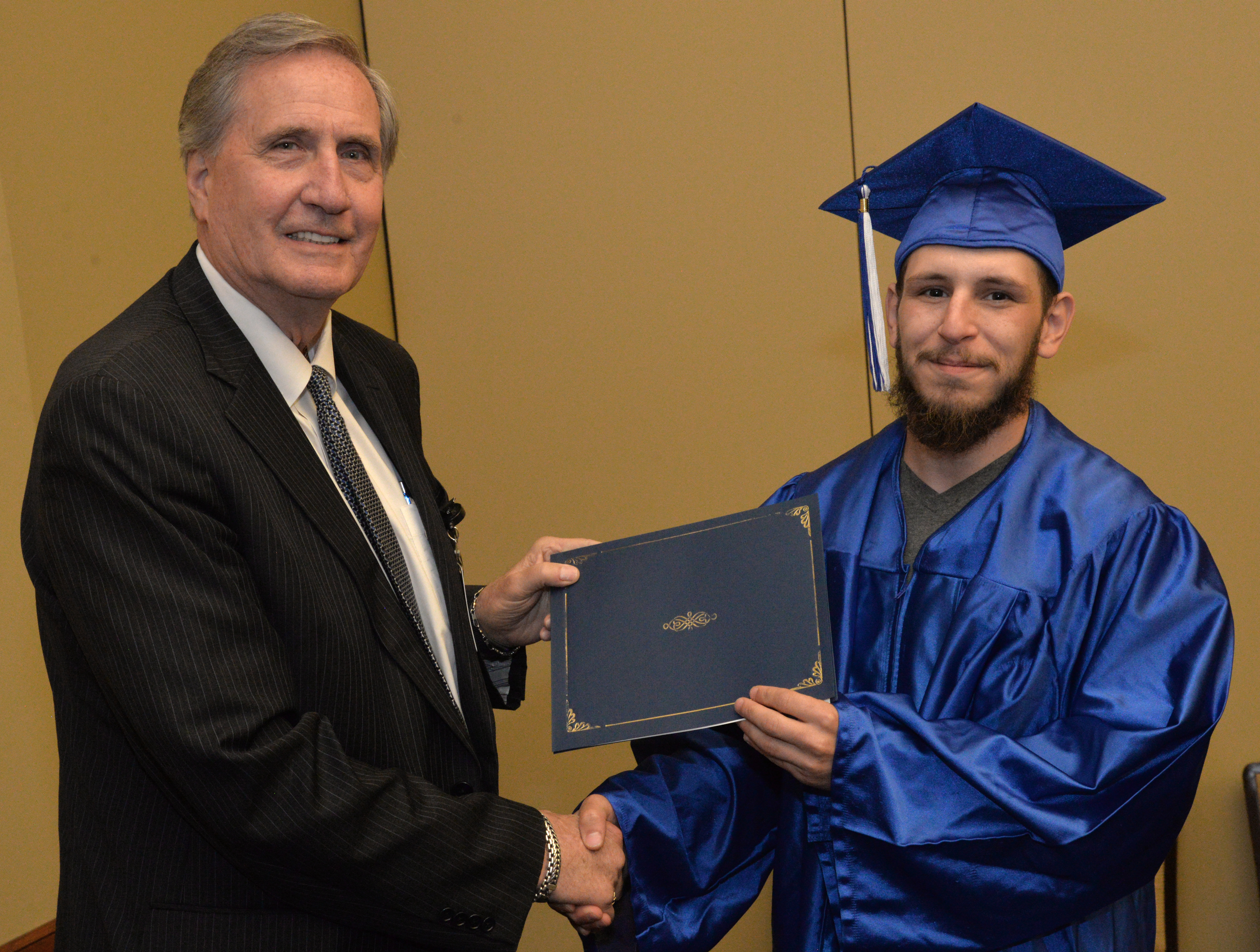 Christian Rodriguez receives his high school diploma from SCC's President, Dr. Don Tomas