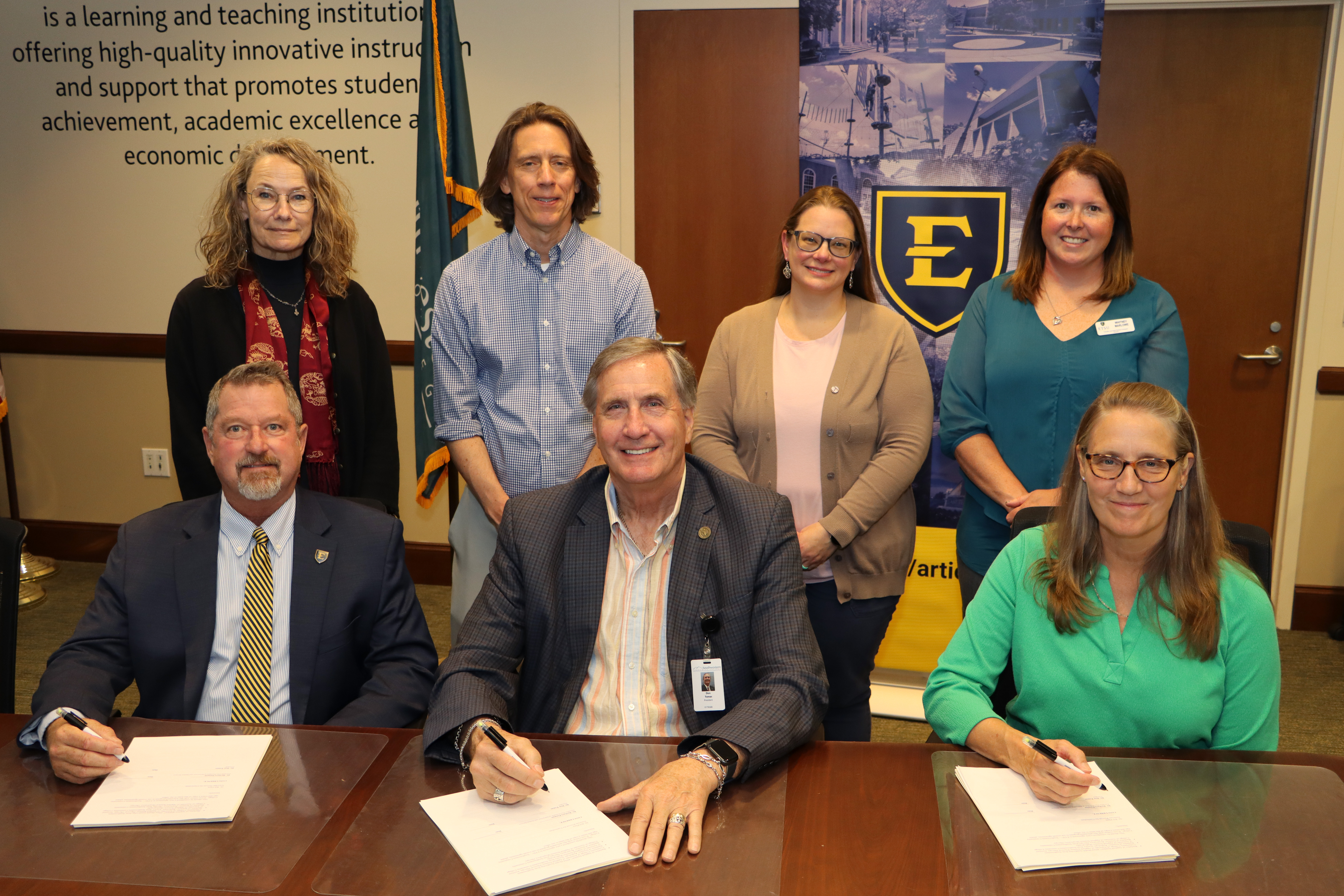 College and university representatives sign the agreement