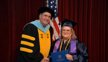SCC President Dr. Don Tomas presents a diploma cover to a graduate in December of 2019, the last time Southwestern held a traditional indoor graduation ceremony