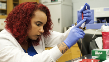 Female student conducts a test in SCC's lab.