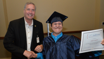 Andy Watty of Sylva (right) proudly shows off his diploma after receiving it from Dr. Don Tomas (left), SCC’s President.