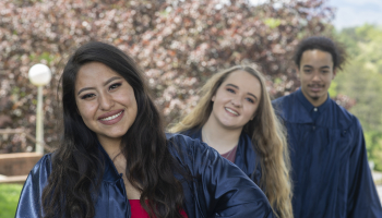 Three graduates smile for the camera