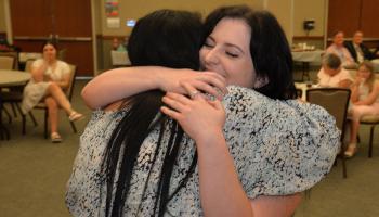 Destiny Hall gets a hug from her instructor during a pinning ceremony