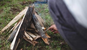Individual igniting a campfire