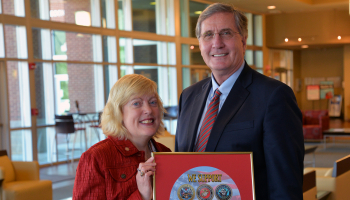 Veterans Council chair Lyn Lazar and SCC president Dr. Don Tomas holding the framed military seals.