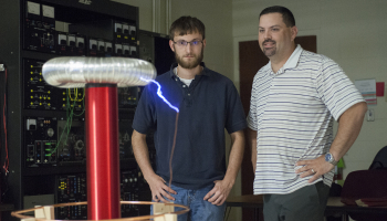 SCC students stand with Tesla Coil they built.