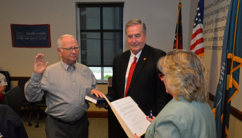 Gerald McKinney is sworn in as Dr. Don Tomas holds a bible.