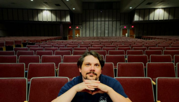 Matt Cass seated in empty auditorium