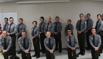 A group of law enforcement students kneel and pose for a picture