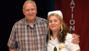 Nursing graduate poses with her family member