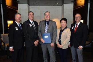 Four men and a woman pose indoors at Harrah's Cherokee Casino Resort.