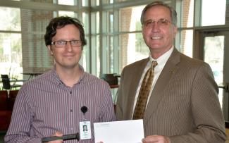Two men exchange an envelope inside a building on SCC's Jackson Campus.