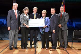 Group of people holding a large check.
