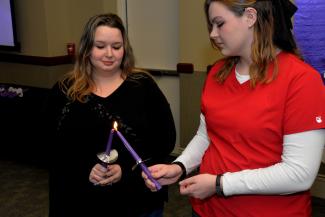 Inductees light their candles