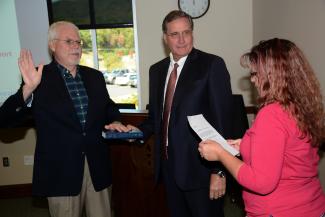 Two men look at woman talking