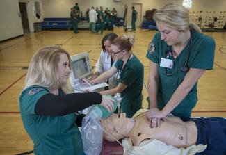 Two girls look at mannequin on table