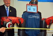 Photo of Baxter the Robot cutting a ribbon during the grand opening of Southwestern Community College’s Advanced Manufacturing Education Lab
