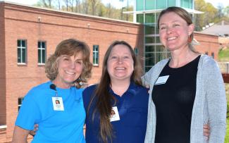 Three ladies stand in front of the Burrell Building on SCC's Jackson Campus
