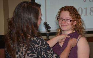 Instructor applies pin to a student's shirt