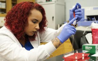 Female student conducts a test in SCC's lab.