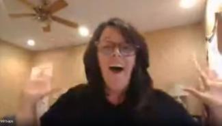 Woman raises arms in celebration.