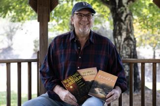 Chris Cox is shown with all three books he's written.