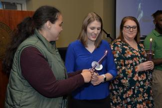 Students hold candles during a ceremony