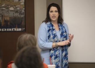 Woman speaks in front of a classroom