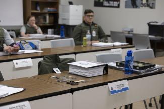 Empty desk surrounded by classmates
