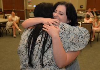 Destiny Hall gets a hug from her instructor during a pinning ceremony