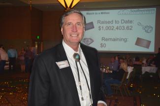 Man stands in front of a projected screen announcing that SCC's Student Success Campaign has reached $1 million.