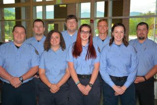 Eight students standing and smiling