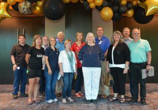 Event planning committee stands inside the space where this year's gala will be held.