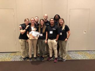 Group of physical therapy students huddle together and celebrate their second place win at quiz bowl