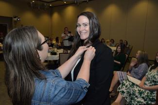 Student receives her pin from instructor Anna Walls