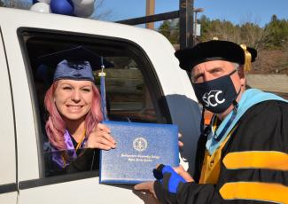 Woman receives diploma cover from SCC president