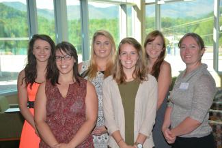 Students smiling with hands in front of them