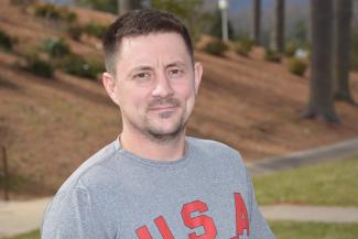 Danny Simmons in a grey shirt with red writing saying USA on it