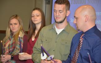 SCC students light candles as part of the ceremony