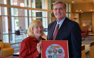 Veterans Council chair Lyn Lazar and SCC president Dr. Don Tomas holding the framed military seals.