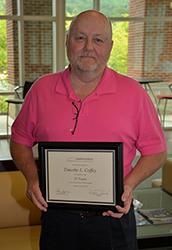 Photo of SCC criminal justice technology program coordinator Tim Coffey, holding a certificate that recognizes his 35 years of service to the state of North Carolina.