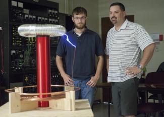 SCC students stand with Tesla Coil they built.