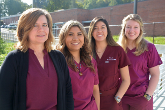 Four ladies stand outdoors