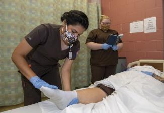Nurse Aide students train with a simulation mannequin in a lab at SCC.